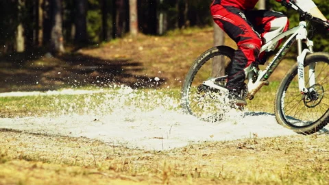 Man riding mtb down the hill in a patch of snow in super slow motion Stock Footage 146858811