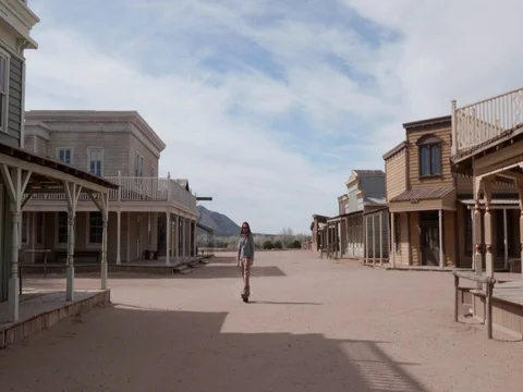 Man Riding One Wheel Threw Western Town towards Stock Footage 84157031