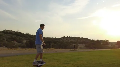 Man Riding OneWheel on Grass Stock Footage 97648538