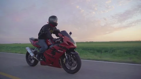 Man riding red motorcycle during sunset 3 Stock Footage 146653064