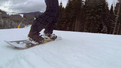 A man is riding a snowboard, close-up from behind Stock Footage 88921608