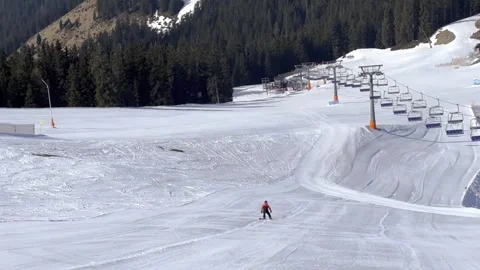 Man is riding on snowboard on empty ski slope. Sunny day, fresh snow in Alps Stock Footage 306583553