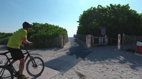 Man riding through pathway and onto the beach Stock Footage 66524524