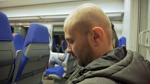 A man is riding a train and looking at the phone. Winter season. Train travel Vídeos de archivo 117751807