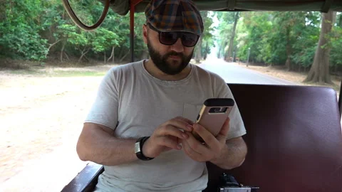 Man riding a tuktuk and using smartphone, slow motion shot at 240fps  Stock Footage 102052565