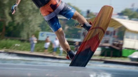 Man riding on wakeboard and doing trick in slow motion Stockbeeldmateriaal 116055446