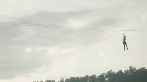Man riding zip line in mountains at height of several metres with grey sky Video stock 78729629