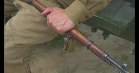 A man with a rifle, dressed in the uniform of a Soviet soldier from World War II Stock Footage 303163040