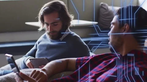 Man on right extending phone toward man on left, causing animated tech graphics Stock Footage 334768417