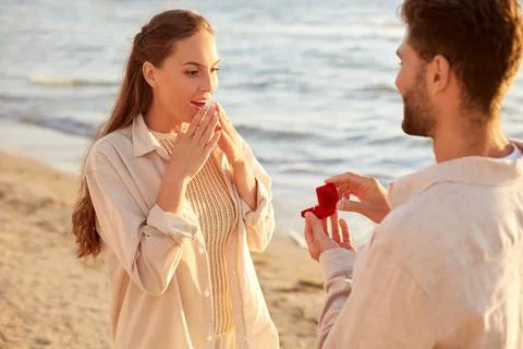 Man with ring making proposal to woman on beach Stock Photos