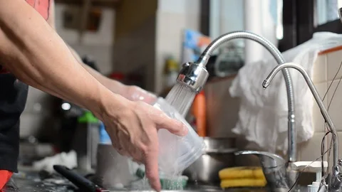 A man rinses previously washed and washed dishes to save water resources. Stock Footage