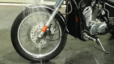 Man rinsing and drying off motorcycle cu of front wheel Stock-Footage 24637098