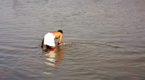 Man ritually bathing in river Stock Footage 23332055