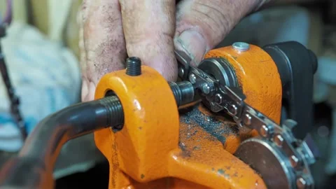 Man rivetes chain saw links with a special riveting machine. Close-up shot with Stock Footage 171962872