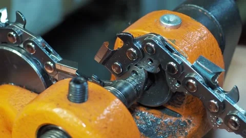 Man rivetes chainsaw chain saw links with riveter. Close-up shot with selective Stock Footage 175172239