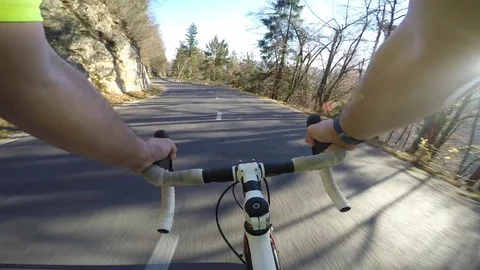 Man road cyclist going fast downhill on asphalt mountain road in the sun Stock Footage 82316543