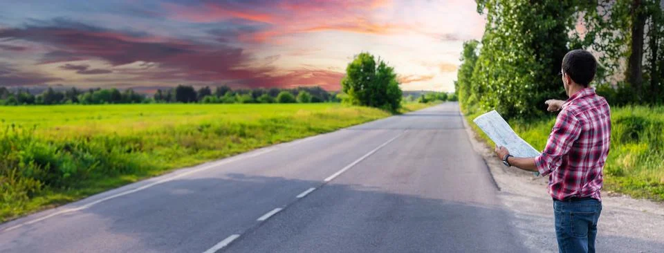 A man on the road is looking at a map. Selective focus. Stock Photos