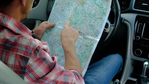A man on the road looks at the map. Selective focus. Stock Footage 243261312