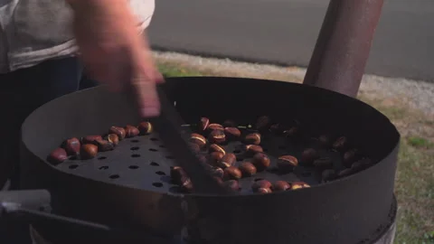 Man roast chestnuts on an open fire Stock Footage 145720256