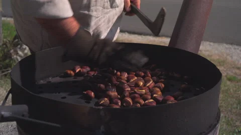 Man roast chestnuts on an open fire Stock Footage 145720459