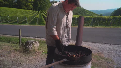 Man roast chestnuts on an open fire Stock Footage 145724349