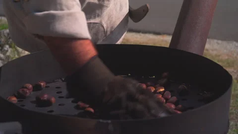 Man roast chestnuts on an open fire Stock Footage 145796154