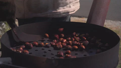 Man roast chestnuts on an open fire Stock Footage 145796578