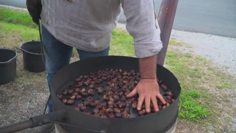 Man roast chestnuts on an open fire Stock Footage 145797045
