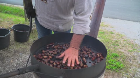 Man roast chestnuts on an open fire Stock Footage 145798237