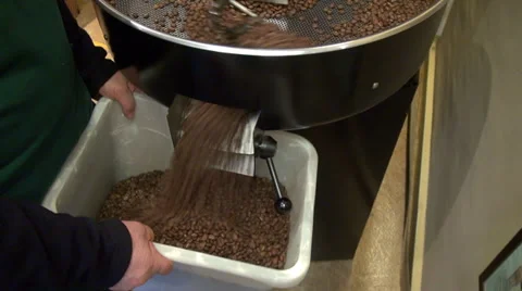 Man roasting coffee beans, machine, coffee beans falling into container Stock Footage 38296525