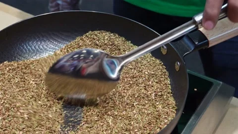 A man roasting dried tea leaves in a pan Stock Footage 197783387
