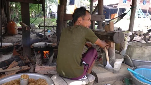Man roasts and flatten rice in traditional khmer flat-rice making process Stock Footage 140897201