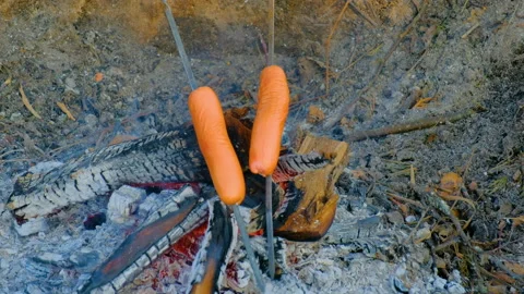 A man roasts sausages on the fire Stockbeeldmateriaal 164380539