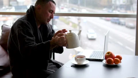 A man in a robe drinks tea after a bath Sleepy casual young man wearing bathrobe Stock-Footage 301681365
