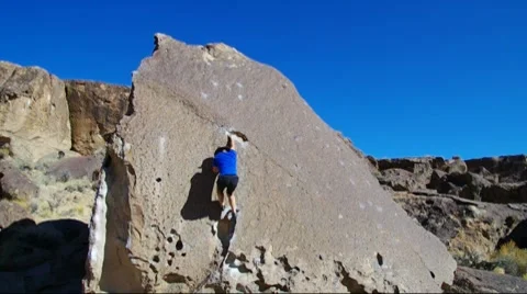 Man rock climbing on a boulder Stock Footage 10745262