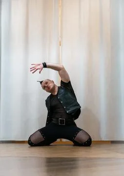 A man in rock clothes performs dance moves. A metal man with a mohawk on hi.. Stock Photos