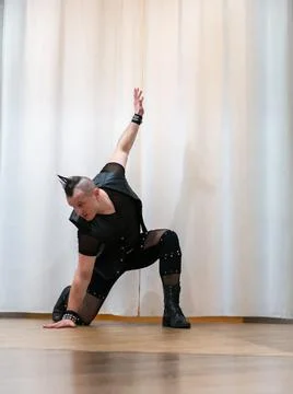 A man in rock clothes performs dance moves. A metal man with a mohawk on hi.. Stock Photos