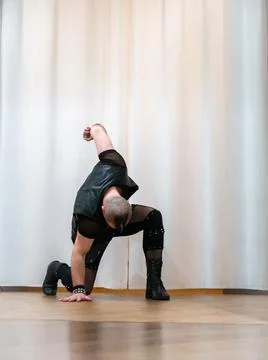 A man in rock clothes performs dance moves. A metal man with a mohawk on hi.. Stock Photos