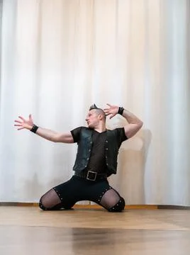A man in rock clothes performs dance moves. A metal man with a mohawk on hi.. Stock Photos