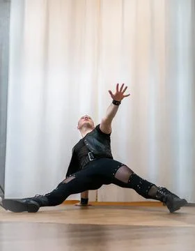 A man in rock clothes performs dance moves. A metal man with a mohawk on hi.. Stock Photos