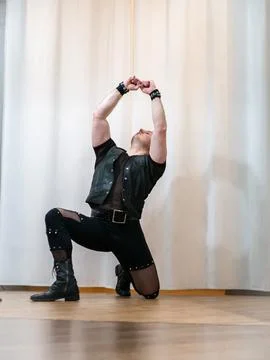 A man in rock clothes performs dance moves. A metal man with a mohawk on hi.. Stock Photos