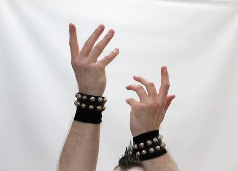 A man in rock clothes performs dance moves. A metal man with a mohawk on hi.. Stock Photos