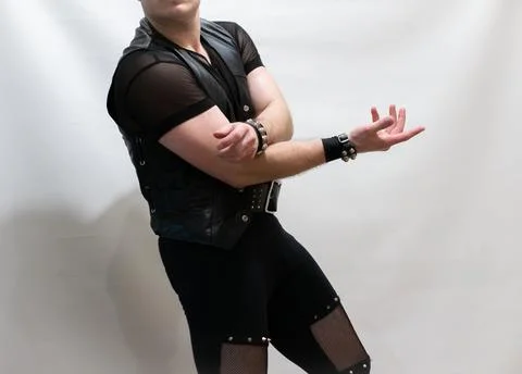 A man in rock clothes performs dance moves. A metal man with a mohawk on hi.. Stock Photos