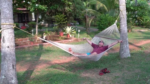 A man is rocking in a hammock Stock Footage 75001637