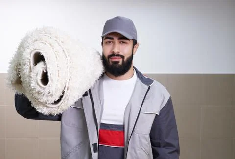 Man with a roll of carpet Stock Photos