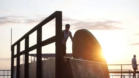 Man on roller skates jumps from a springboard and rides further Stock-Footage 102776360