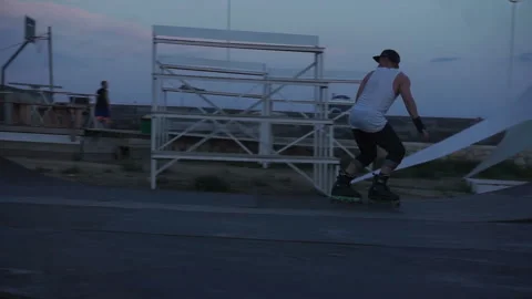 Man on roller skates rides back forward and climbs the springboard Stock-Footage 102786899