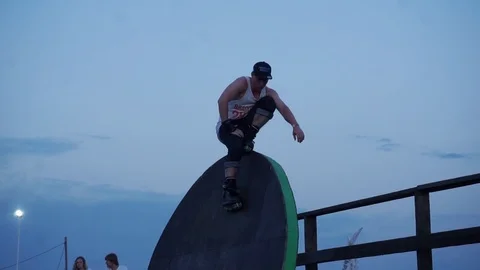 Man on roller skates sits on an obstacle and rests Video stock 102779582