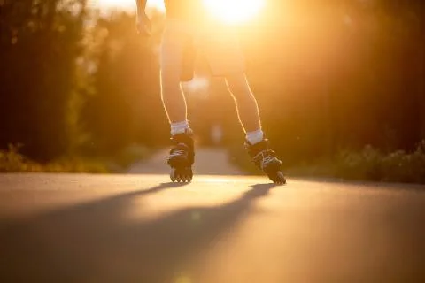 Man roller skating on the cycle path during lovely summer sunset, sport concept Fotos Stock