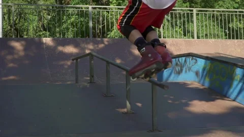 Aggressive inline rollerblader grinding on rail in skatepark Stock